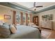 Spacious main bedroom featuring tray ceiling, wood floors, sitting area, and a wall of windows overlooking the pool at 402 S Lake Victoria Cir, Deland, FL 32724