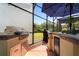 Screened outdoor kitchen features a built-in grill, mini fridge, and views of the backyard at 402 S Lake Victoria Cir, Deland, FL 32724