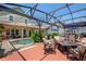 An outdoor area with comfortable seating and a fire pit perfect for gatherings, with a pool and an outdoor kitchen in the background at 402 S Lake Victoria Cir, Deland, FL 32724