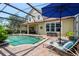 A well-maintained pool area with lounge chairs, a covered patio, and lush landscaping for a private and relaxing outdoor experience at 402 S Lake Victoria Cir, Deland, FL 32724