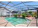 Inviting screened pool area with brick pavers, outdoor seating, and a built in bar area with television for the ultimate relaxation at 402 S Lake Victoria Cir, Deland, FL 32724