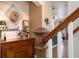 Staircase with wooden banister leads upstairs from hallway featuring stylish decor and lighting at 402 S Lake Victoria Cir, Deland, FL 32724