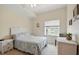 Bright bedroom with white wicker furniture and a large sunny window at 5300 S Atlantic Ave # 6-507, New Smyrna Beach, FL 32169