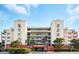 Beautiful condominium complex with lush landscaping, covered parking, and blue balcony railings at 5300 S Atlantic Ave # 6-507, New Smyrna Beach, FL 32169
