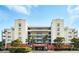 Multi-story condominium exterior featuring balconies, landscaping, and convenient covered parking at 5300 S Atlantic Ave # 6-507, New Smyrna Beach, FL 32169