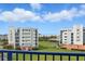 Scenic view of neighboring buildings surrounded by manicured green lawns, tropical trees, and blue sky at 5300 S Atlantic Ave # 6-507, New Smyrna Beach, FL 32169
