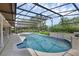 Screened-in pool with an attached spa, surrounded by lush landscaping, and a brick retaining wall at 633 N Longview Pl, Longwood, FL 32779