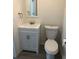 Bathroom featuring a toilet, vanity with white cabinetry, and modern fixtures, with neutral paint and wood look flooring at 647 Madison Ave, Daytona Beach, FL 32114