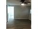 Bedroom with wood look flooring and neutral colored walls, plus a ceiling fan and a doorway leading into a bathroom at 647 Madison Ave, Daytona Beach, FL 32114