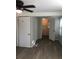 Bedroom with a ceiling fan and wood look flooring leading into a bathroom; features a window for natural light at 647 Madison Ave, Daytona Beach, FL 32114