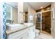 A Primary bath with double sinks, granite counters, decorative backsplash, and a tiled glass shower at 7572 Sunny Dreams Ln, Kissimmee, FL 34747