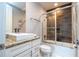 Bathroom featuring granite countertops, white cabinets, and a shower/tub combo with glass doors at 7572 Sunny Dreams Ln, Kissimmee, FL 34747