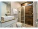 A bathroom featuring a modern vanity with granite countertops and a walk-in shower with wood-style tiling at 7572 Sunny Dreams Ln, Kissimmee, FL 34747