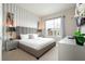 Bright bedroom with large window, neutral decor, and gray striped accent wall at 7572 Sunny Dreams Ln, Kissimmee, FL 34747