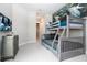 A bedroom featuring bunk beds with gray trim, a TV, and ample space for relaxation and play at 7572 Sunny Dreams Ln, Kissimmee, FL 34747