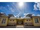 Yellow building with stone accents frames a pool entrance against a bright blue sky at 7572 Sunny Dreams Ln, Kissimmee, FL 34747