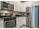 A kitchen featuring stainless steel appliances, granite countertops, white cabinets, and a stylish tile backsplash at 7572 Sunny Dreams Ln, Kissimmee, FL 34747