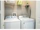 A well-lit laundry room features a white washer and dryer with wire shelving for storage at 7572 Sunny Dreams Ln, Kissimmee, FL 34747