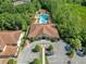Aerial view of community clubhouse and pool surrounded by lush greenery and parking at 8215 Roseville Blvd, Davenport, FL 33896