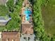 Overhead view of the community pool and clubhouse surrounded by lush greenery and serene landscaping at 8215 Roseville Blvd, Davenport, FL 33896