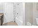 Bright bathroom with tub-shower combo and white fixtures, complemented by neutral tile flooring at 8215 Roseville Blvd, Davenport, FL 33896