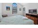 Bright bedroom with vaulted ceiling, arched window, television, and modern furnishings at 8215 Roseville Blvd, Davenport, FL 33896