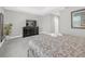 Cozy bedroom featuring soft carpet, neutral walls, and a sleek black dresser with a television at 8215 Roseville Blvd, Davenport, FL 33896