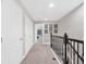 Second floor hallway showcasing a carpeted floor, white doors, and decorative accents, creating a bright and inviting space at 8215 Roseville Blvd, Davenport, FL 33896