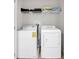 Efficient laundry room features a washer, dryer, and storage for household cleaning at 8215 Roseville Blvd, Davenport, FL 33896