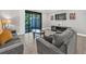 Inviting living room with neutral colors, tile flooring, plush seating, and sliding glass door access to outdoor space at 8215 Roseville Blvd, Davenport, FL 33896