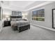 Serene main bedroom featuring a tray ceiling, plush carpet, a large window, and stylish furnishings for a relaxing retreat at 8215 Roseville Blvd, Davenport, FL 33896