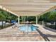 Relaxing jacuzzi area with covered pergola, tiled deck, and handicap lift access at 8215 Roseville Blvd, Davenport, FL 33896