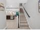 View of the staircase highlighting the open layout with the kitchen and living room visible in the background at 8215 Roseville Blvd, Davenport, FL 33896