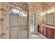 Bathroom with a glass vessel sink, shower, and striking palm tree wallpaper at 8713 S Bay Dr, Orlando, FL 32819
