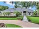 Beautiful one-story home featuring mature landscaping and a stone walkway leading to the front door at 8713 S Bay Dr, Orlando, FL 32819