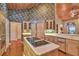 Kitchen with an island cooktop, light wood cabinets, stone countertops and hardwood floors at 8713 S Bay Dr, Orlando, FL 32819