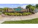 Welcoming entrance to Amber Ridge with brick signage, lush landscaping, and manicured flower beds at 896 Satin Leaf Cir, Ocoee, FL 34761