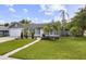 Single-story house features a bright green lawn, walkway, and tropical landscaping, creating a welcoming entrance at 896 Satin Leaf Cir, Ocoee, FL 34761