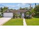 Inviting one-story residence boasts a manicured lawn, tidy landscaping, and an attached two-car garage at 896 Satin Leaf Cir, Ocoee, FL 34761