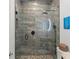 Walk-in shower with gray tilework and matte black fixtures at 9724 Chestnut Ridge Dr, Windermere, FL 34786