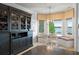 Charming breakfast nook with built-in seating, bay windows overlooking the lake, and stylish display cabinet at 9724 Chestnut Ridge Dr, Windermere, FL 34786