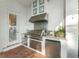 Outdoor kitchen features a sink, stainless grill, a vent, and mini fridge for easy entertaining at 9724 Chestnut Ridge Dr, Windermere, FL 34786