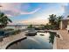 Relaxing backyard pool with a hot tub overlooking the lake and clear blue sky at 9724 Chestnut Ridge Dr, Windermere, FL 34786