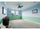 A playroom with a blue and green color scheme, ceiling fan, and a pair of large windows at 9736 Hatton Cir, Orlando, FL 32832