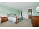A relaxing bedroom with an iron bed frame, a view into the bathroom, and soft green walls at 9736 Hatton Cir, Orlando, FL 32832
