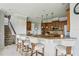 Spacious kitchen featuring wood cabinets, granite countertops, breakfast bar, and staircase access at 9736 Hatton Cir, Orlando, FL 32832