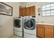 Well-equipped laundry room featuring side-by-side washer and dryer units plus storage cabinets at 9736 Hatton Cir, Orlando, FL 32832