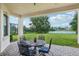 Covered patio with outdoor seating and views of the lawn and pond at 9736 Hatton Cir, Orlando, FL 32832