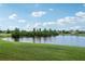 Picturesque pond view with lush green grass and scattered clouds, creating a serene and tranquil setting at 9736 Hatton Cir, Orlando, FL 32832