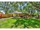 Backyard with a green lawn, wood fence, garden and a pergola at 1608 Victoria Way, Winter Garden, FL 34787